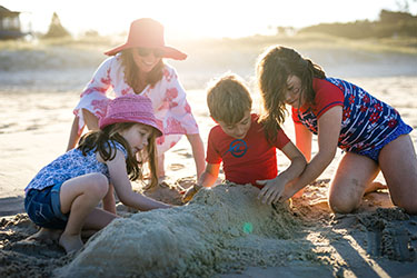 Kids and mum building a sandcastle