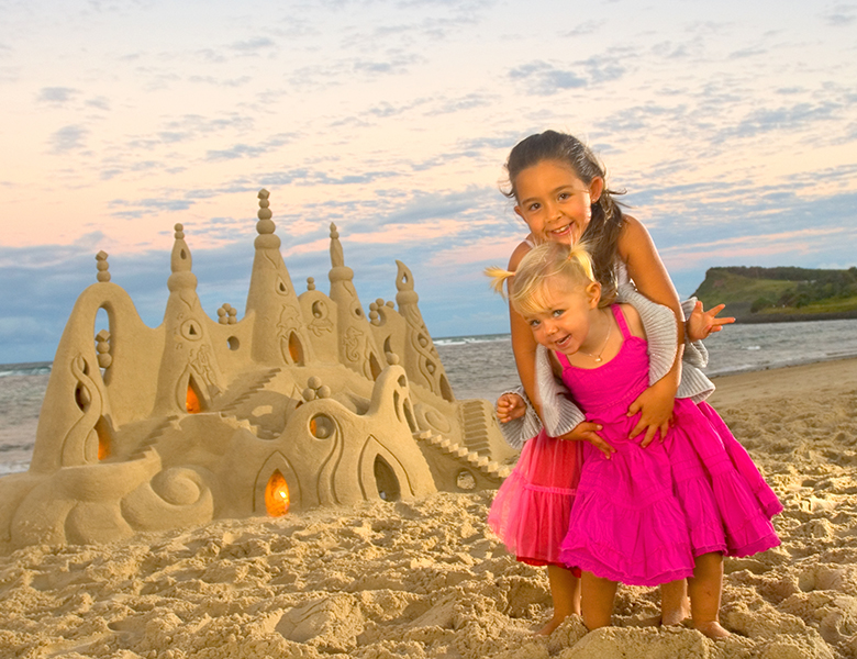 Girls building a sandcastle at the beach