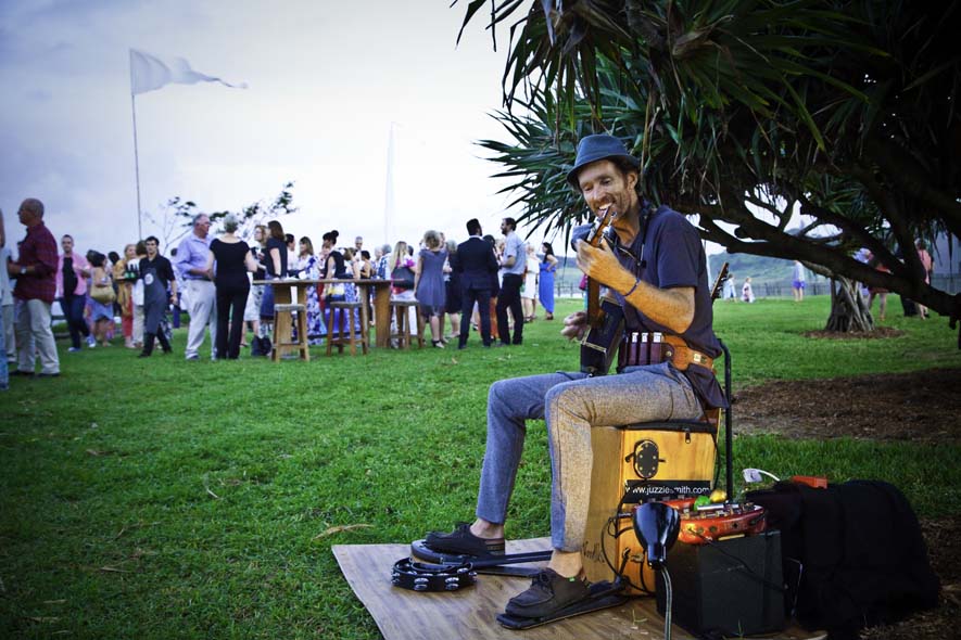 Performer playing guitar with crowd in background