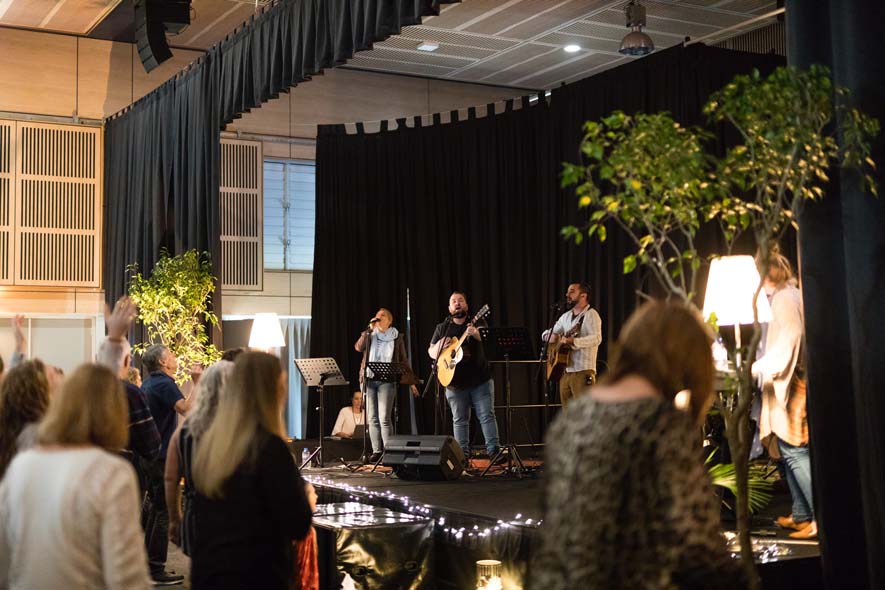 Band playing on stage with people watching