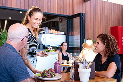 Couple dining at Belle General being served by a smiling waitress