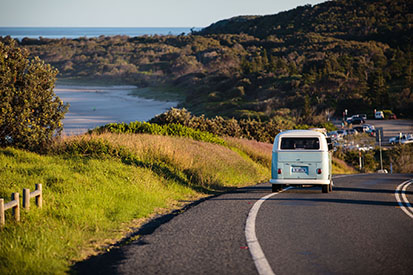 Kombi driving along Coast Road with views of Sharpes Beach