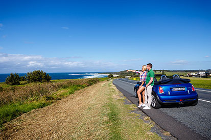 Couple pointing towards beach enjoying the coast view