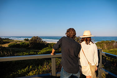 Couple standing at lookout taking in the beach view
