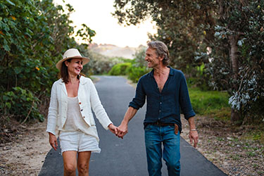 Couple holding hands along footpath