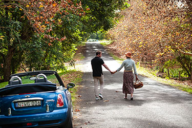 Couple holding hands walking along country road