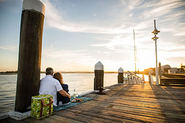 Couple watching sunset from Lance Ferris Wharf 