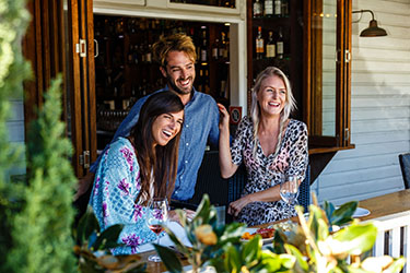 Ladies sitting on verandah at Harvest laughing