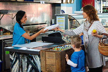 Lady being served her fresh seafood from co-op