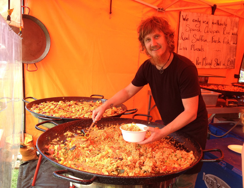 Food stallholder at Byron Markets serving paela