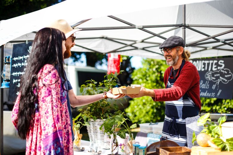 Couple being served my vendor at market