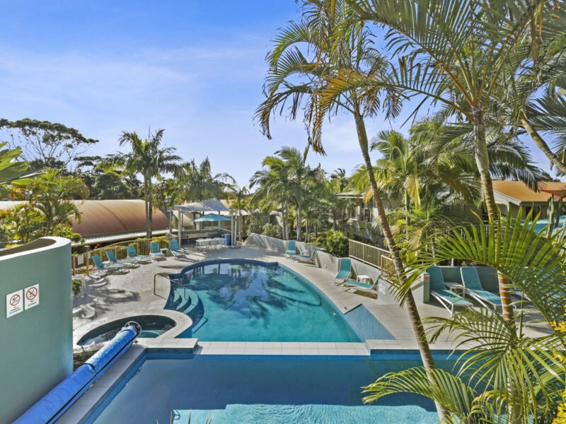 Tropical resort-style pool surrounded by palm trees at Lennox Beach Resort in Lennox Head NSW