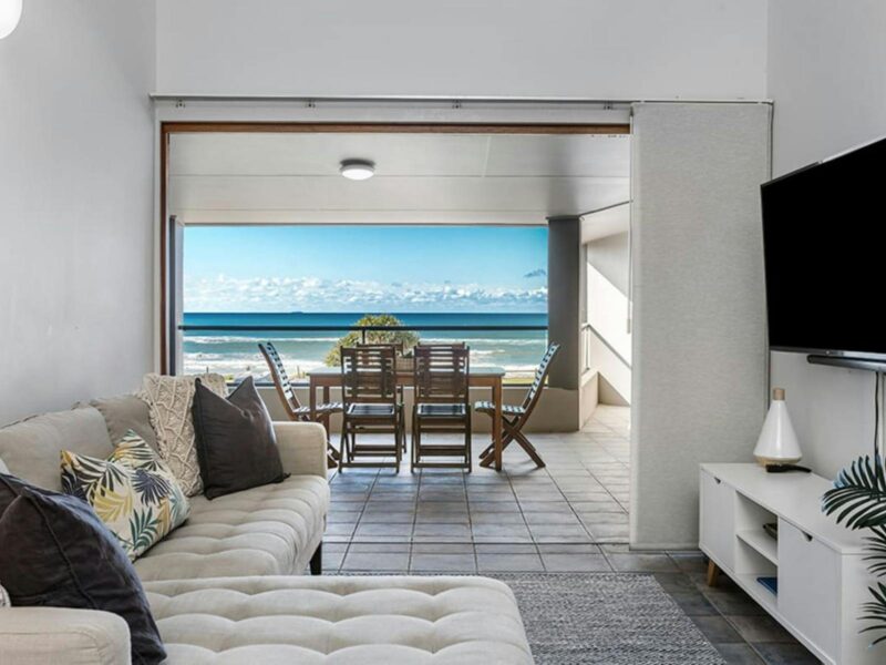 living room overlooking outdoor patio with ocean views