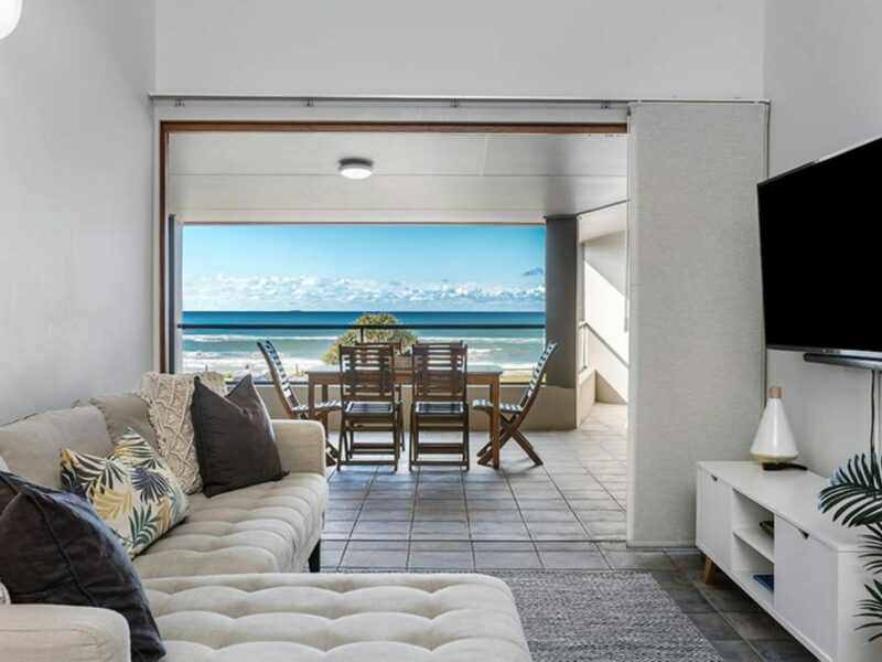 living room overlooking outdoor patio with ocean views