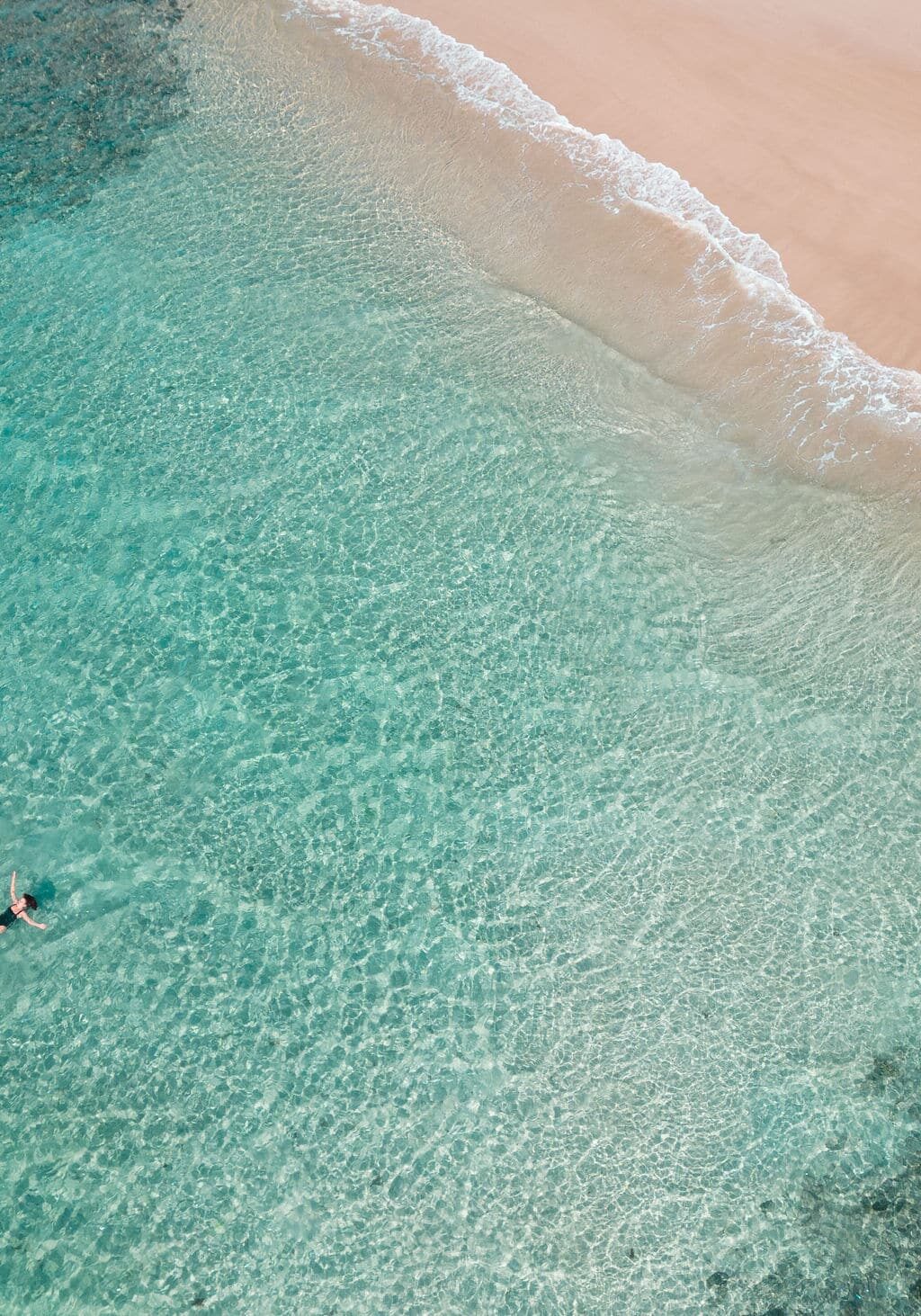 Boat Channel, Lennox Head Aerial view of two people floating in crystal-clear turquoise water near a pristine Boat Channel in Lennox Head, NSW