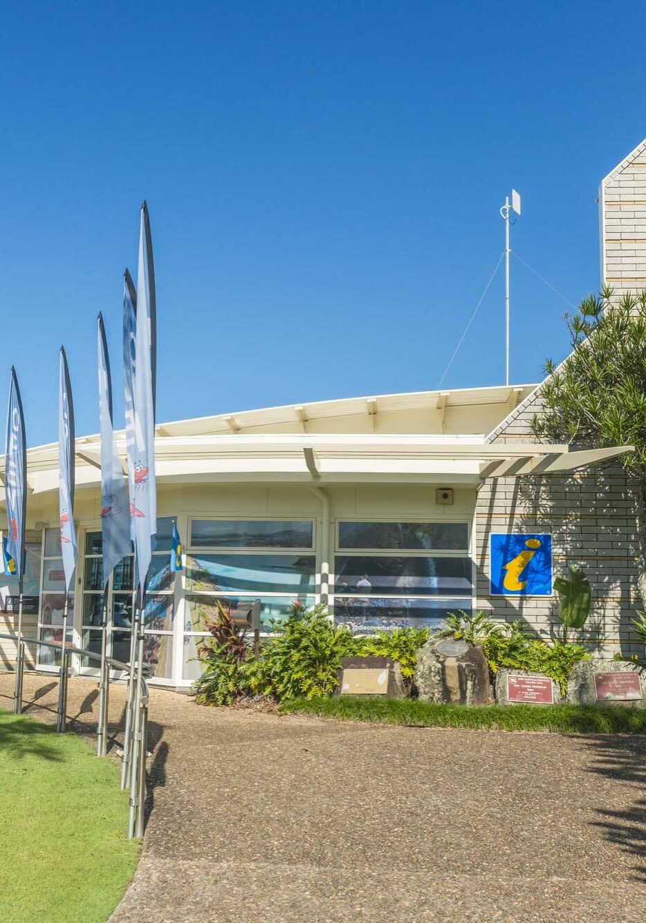 Ballina Visitor Centre visitor centre building with path leading to entrance and flags out the front