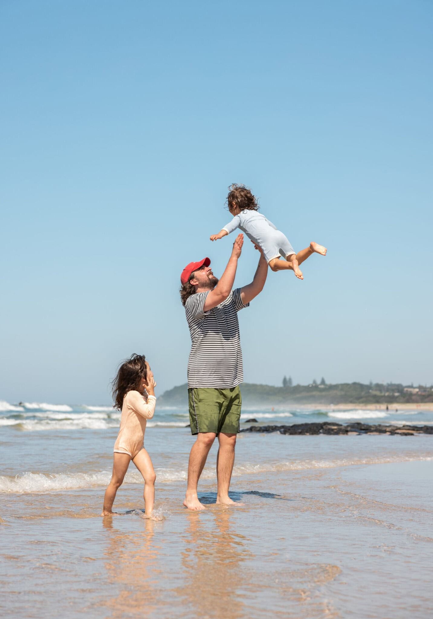 Family Beach Fun in Ballina Coast & Hinterland Father playing with two young children at the beach in Ballina, NSW, enjoying a sunny family day by the ocean.