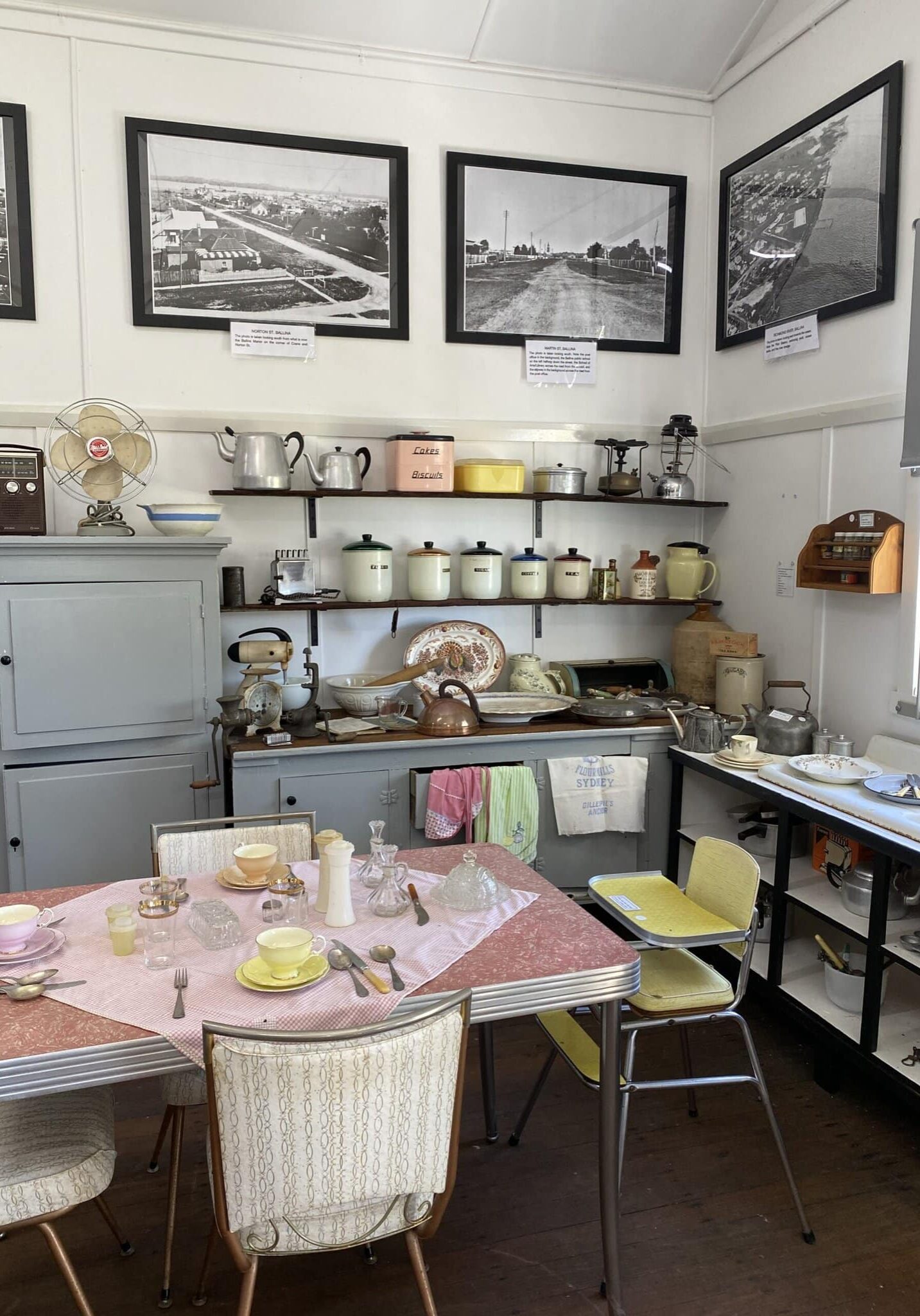 Vintage Kitchen Display – Ballina District Historical Museum, NSW Vintage kitchen exhibit at the Ballina District Historical Museum, featuring 20th-century crockery, appliances, utensils, and black-and-white photographs on the wall.